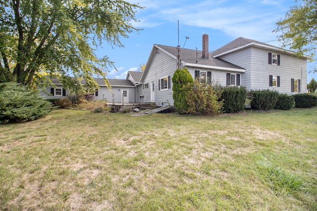 rear view of property with a lawn