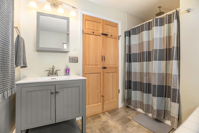 bathroom with a shower with shower curtain, vanity, and a textured ceiling