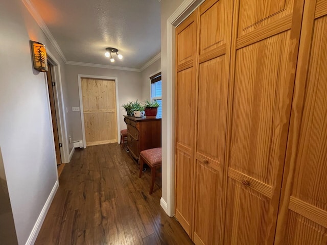 corridor with baseboard heating, dark hardwood / wood-style flooring, and crown molding