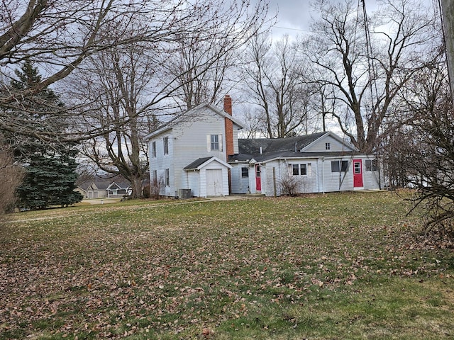 rear view of property featuring a yard and central AC