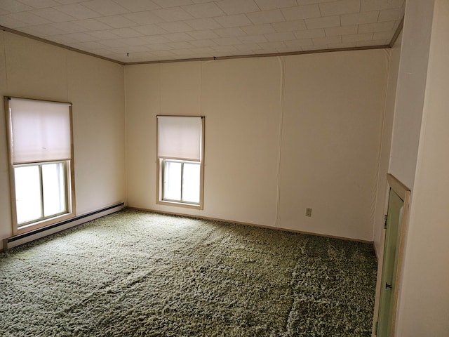 unfurnished room with plenty of natural light, a baseboard heating unit, and carpet