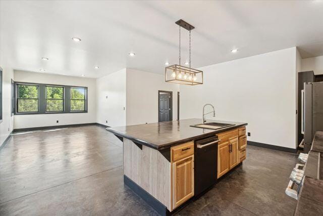 kitchen featuring a kitchen island with sink, stainless steel refrigerator, sink, hanging light fixtures, and dishwasher