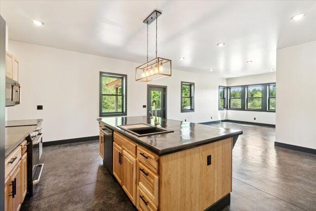 kitchen featuring decorative light fixtures, appliances with stainless steel finishes, sink, and a center island