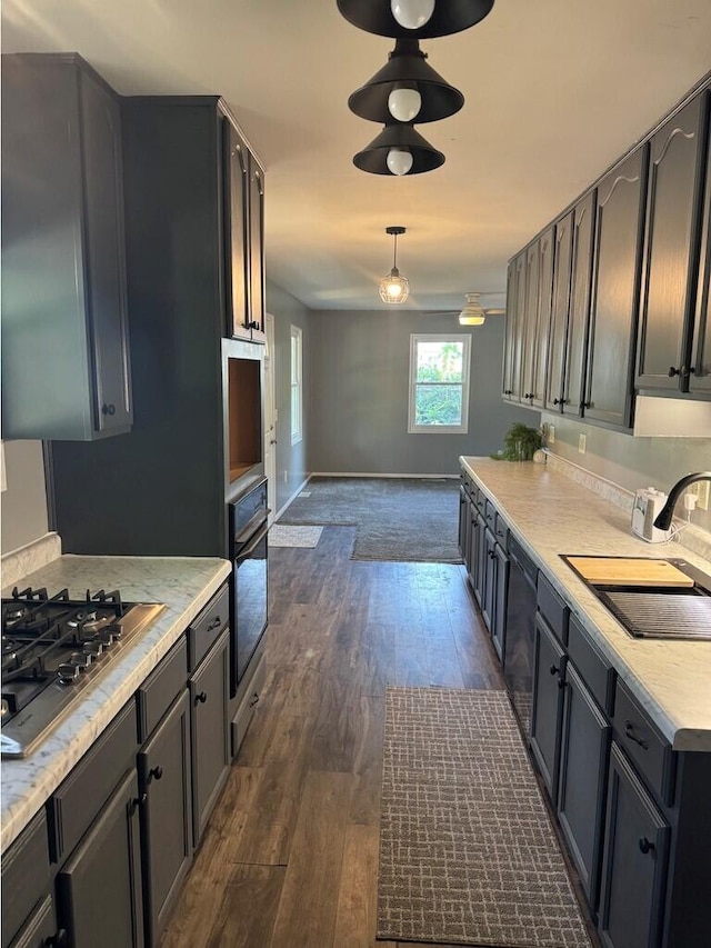 kitchen featuring sink, stainless steel appliances, dark hardwood / wood-style flooring, and pendant lighting