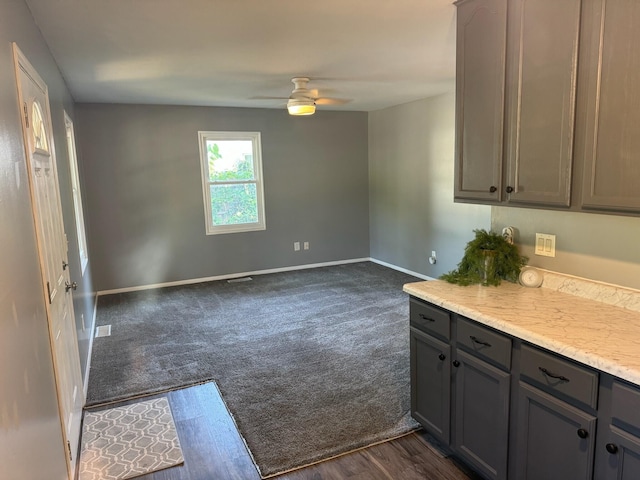 kitchen with ceiling fan, dark carpet, and gray cabinetry