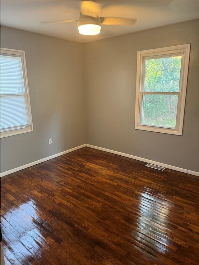 spare room featuring dark hardwood / wood-style flooring and ceiling fan