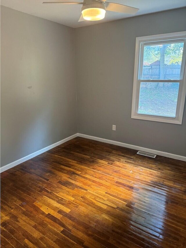 spare room featuring dark wood-type flooring and ceiling fan