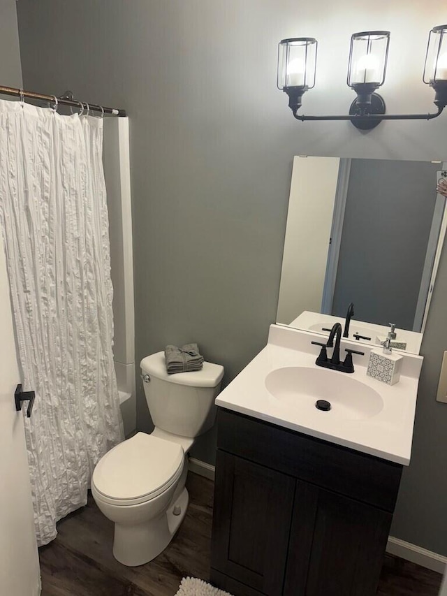 full bathroom with vanity, hardwood / wood-style floors, shower / bath combo, and toilet