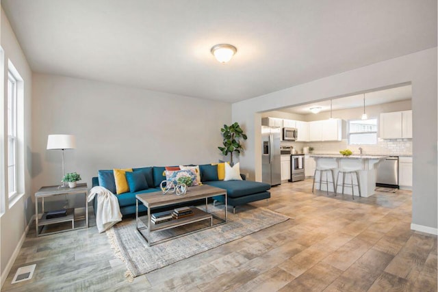 living room with light hardwood / wood-style flooring and sink