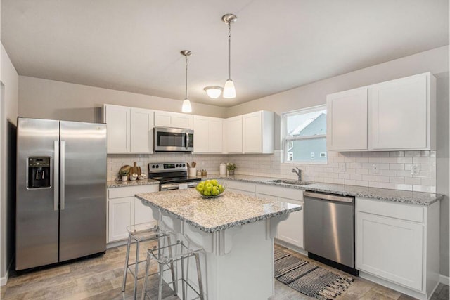 kitchen with stainless steel appliances, pendant lighting, white cabinets, and sink