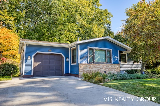 single story home with brick siding, a garage, and driveway