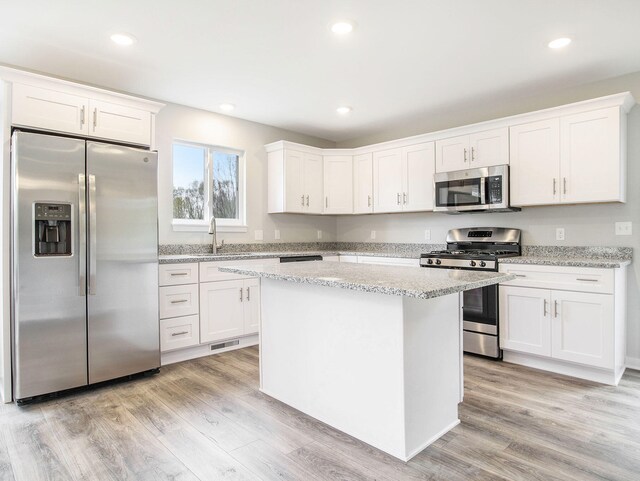 kitchen featuring light hardwood / wood-style floors, white cabinets, and stainless steel appliances