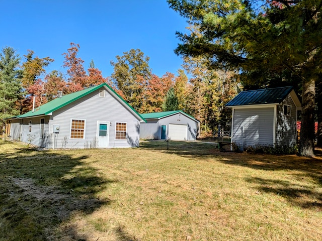 exterior space with a lawn, a garage, and an outdoor structure