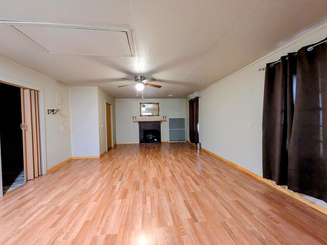 unfurnished living room with light hardwood / wood-style floors, a fireplace, and ceiling fan