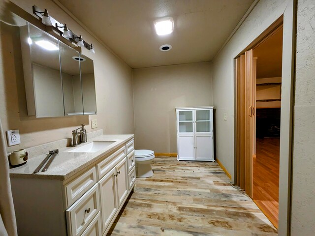 bathroom featuring vanity, hardwood / wood-style flooring, and toilet