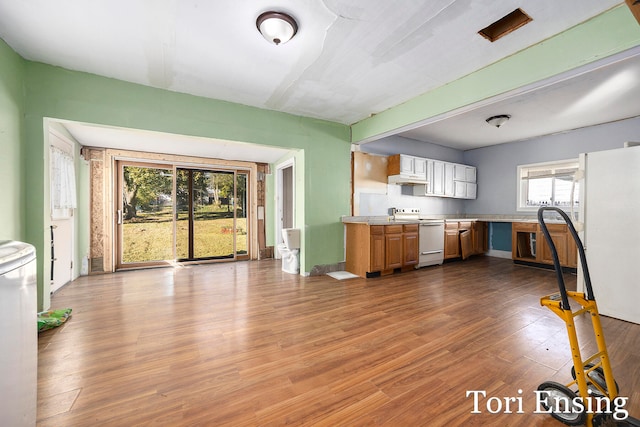 kitchen with premium range hood, light wood-type flooring, and white appliances