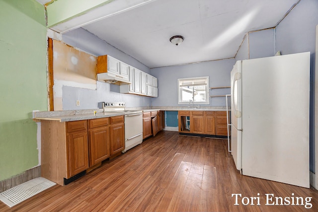 kitchen with hardwood / wood-style flooring, sink, and white appliances