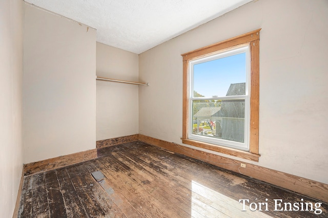 empty room featuring a textured ceiling and hardwood / wood-style flooring