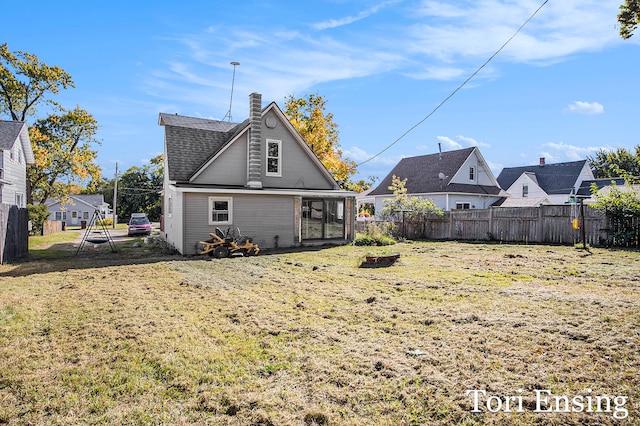 rear view of property featuring a lawn