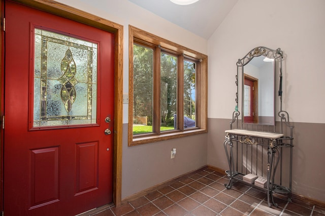 foyer featuring tile patterned floors and vaulted ceiling