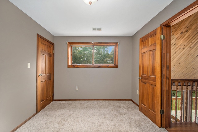 unfurnished bedroom featuring light carpet and multiple windows