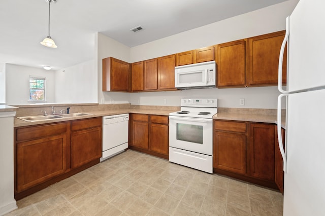 kitchen featuring sink, hanging light fixtures, and white appliances