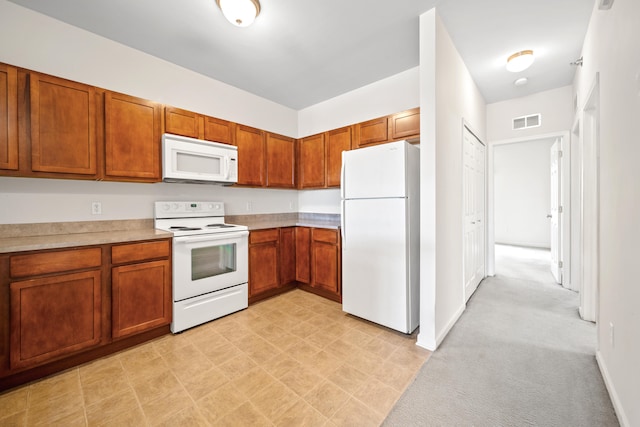 kitchen featuring light colored carpet and white appliances