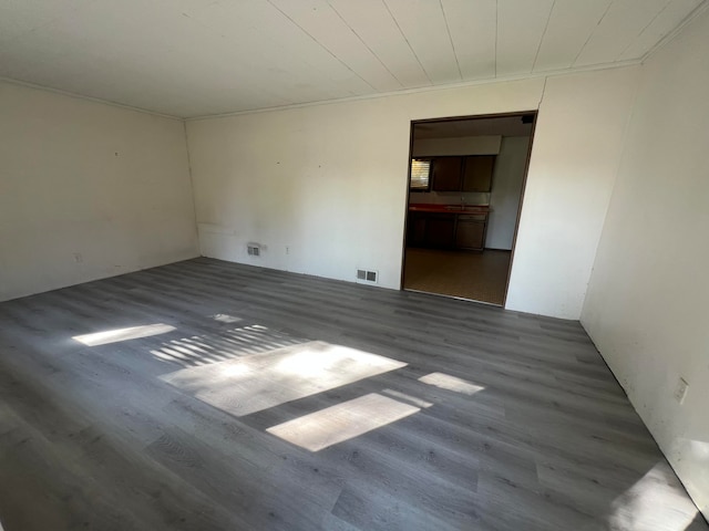 spare room with ornamental molding and hardwood / wood-style floors