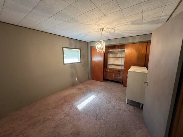 carpeted empty room with a notable chandelier