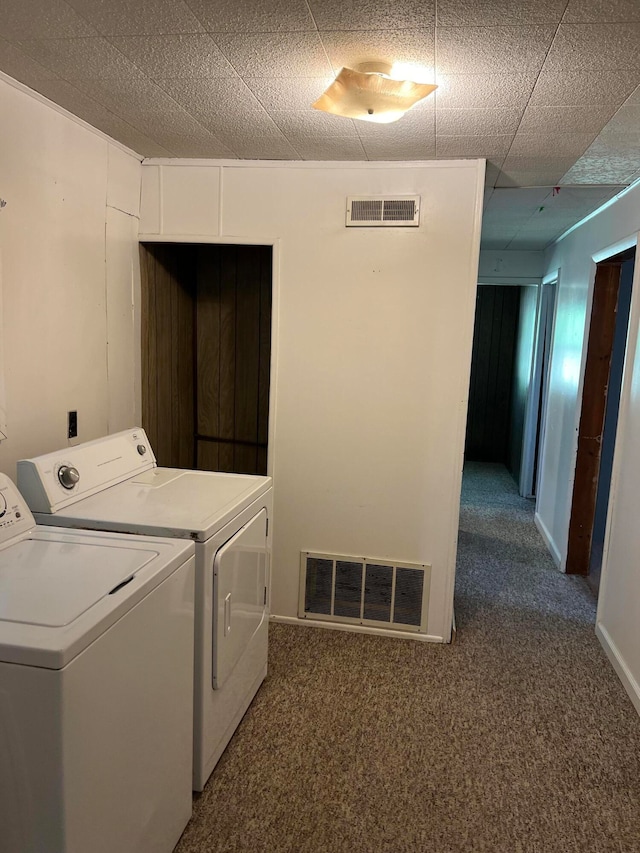 laundry area with washer and dryer and dark colored carpet