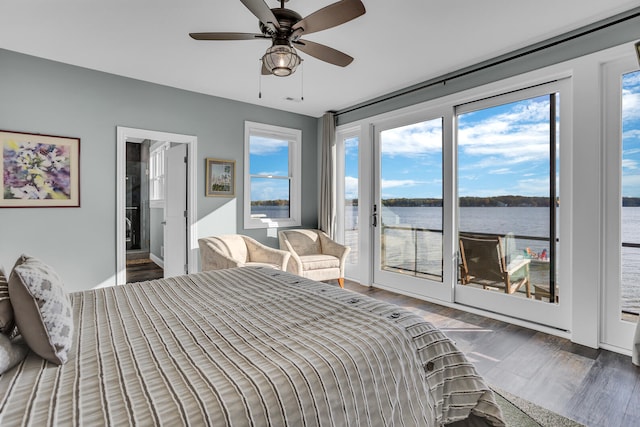 bedroom featuring access to exterior, ceiling fan, a water view, and dark hardwood / wood-style flooring