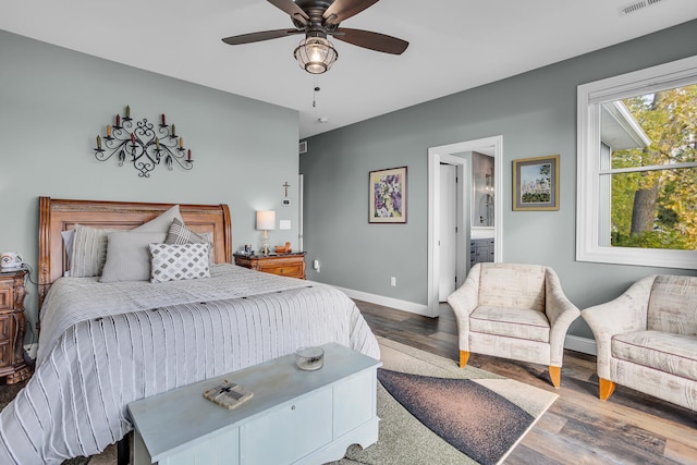 bedroom with dark hardwood / wood-style flooring, ceiling fan, and ensuite bath