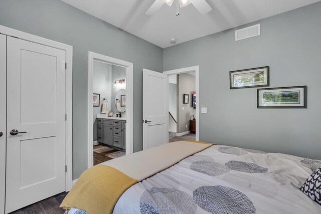 bedroom with dark wood-type flooring, ceiling fan, ensuite bathroom, and sink