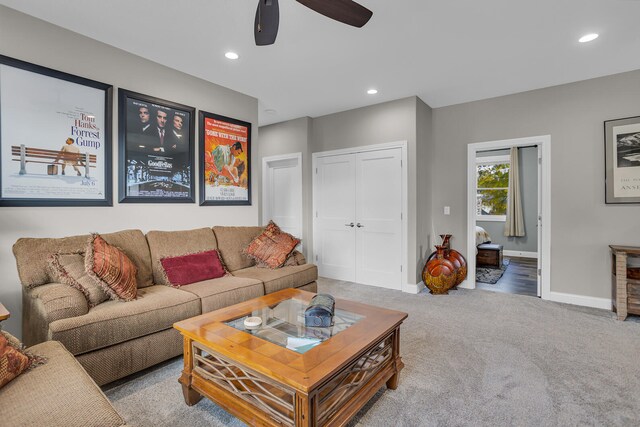 carpeted living room with ceiling fan