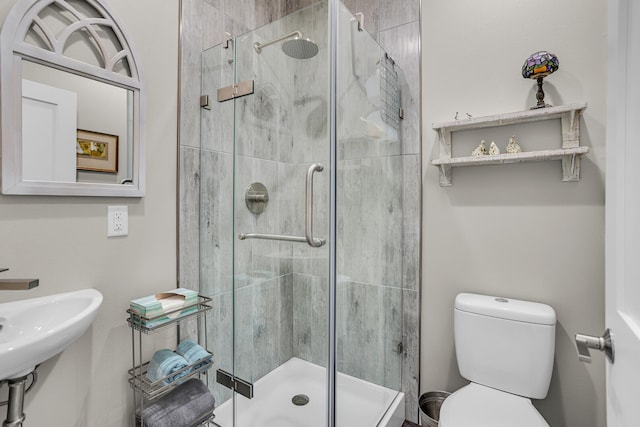 bathroom with toilet and a shower with shower door