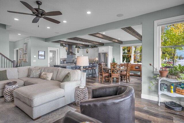 living room with ceiling fan, beam ceiling, and dark hardwood / wood-style floors