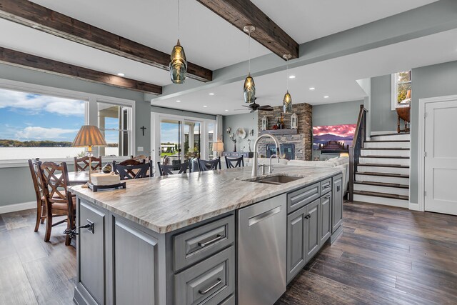 kitchen featuring dishwasher, an island with sink, beamed ceiling, gray cabinets, and dark hardwood / wood-style floors