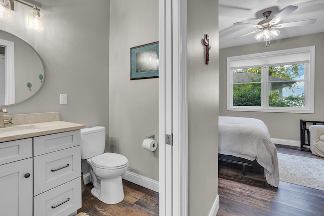 bathroom featuring toilet, hardwood / wood-style floors, vanity, and ceiling fan