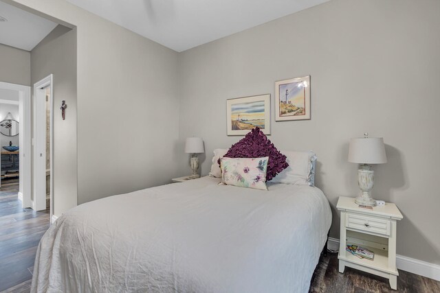 bedroom with dark hardwood / wood-style floors