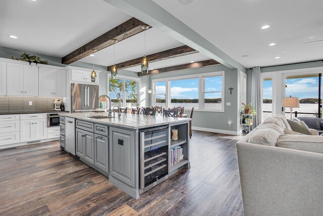 kitchen featuring white cabinets, pendant lighting, high end fridge, and beverage cooler