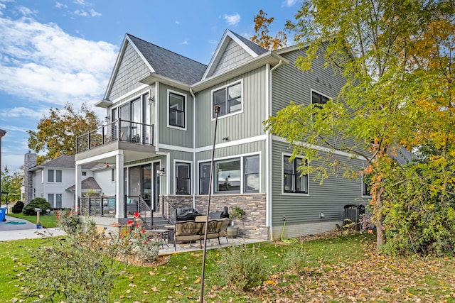 rear view of property with a patio area, a lawn, a balcony, and outdoor lounge area