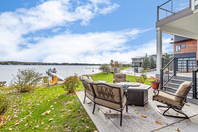 view of patio / terrace featuring a balcony, outdoor lounge area, and a water view