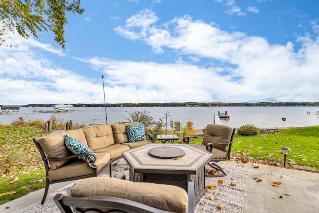 view of patio / terrace with a water view and an outdoor living space with a fire pit