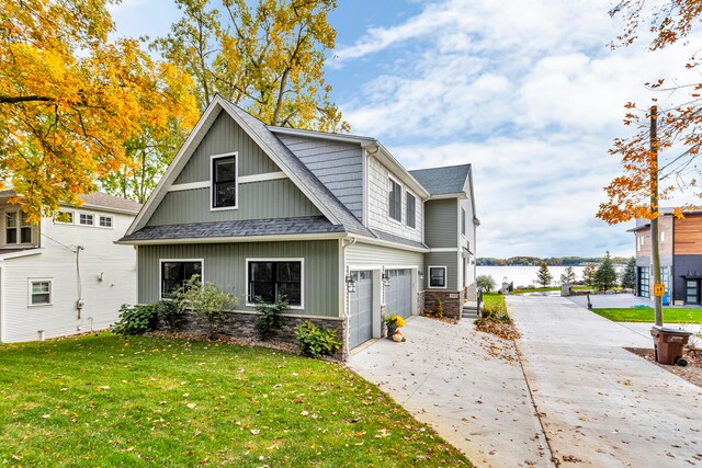 view of front of home featuring a water view, a front lawn, and a garage