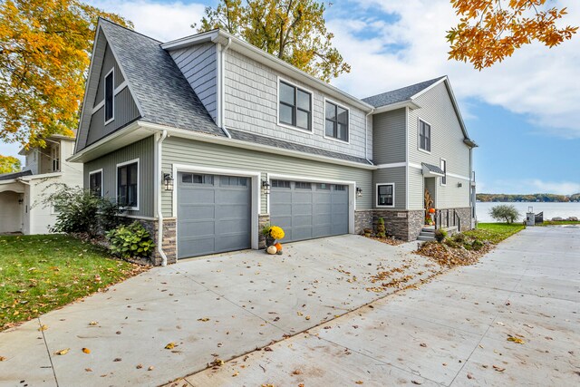 view of side of home featuring a garage and a water view