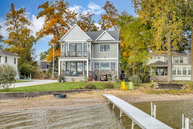 back of house with a balcony, a water view, and a sunroom