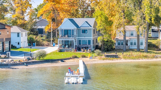 exterior space featuring a yard, a water view, and a balcony