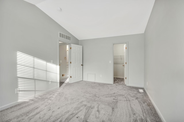 carpeted empty room with vaulted ceiling