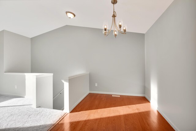 interior space with an inviting chandelier, light wood-type flooring, and vaulted ceiling