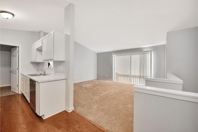 kitchen featuring dishwasher, sink, hardwood / wood-style floors, lofted ceiling, and white cabinets